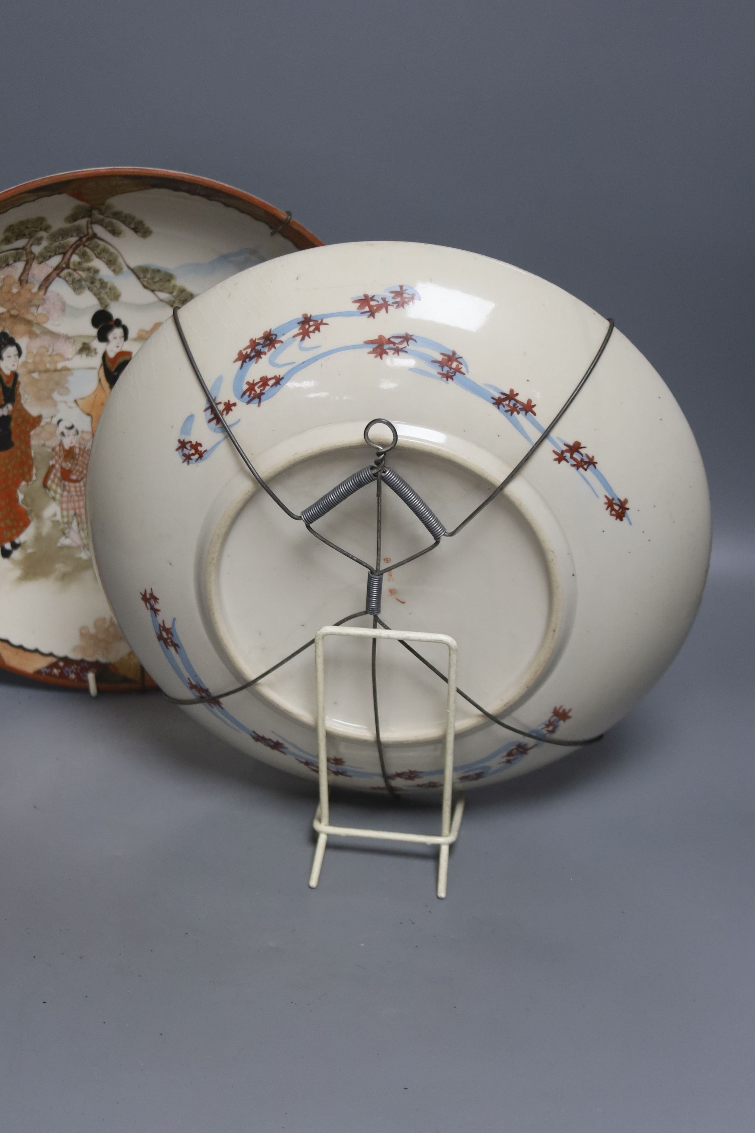 A late 19th century Japanese porcelain oval dish, 29cm, and a pair of Kutani style wall plates, 30cm